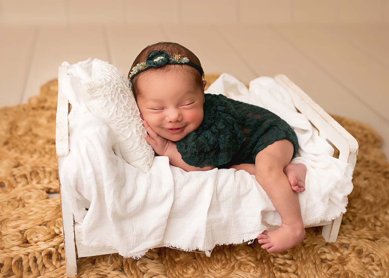 smiling newborn in green